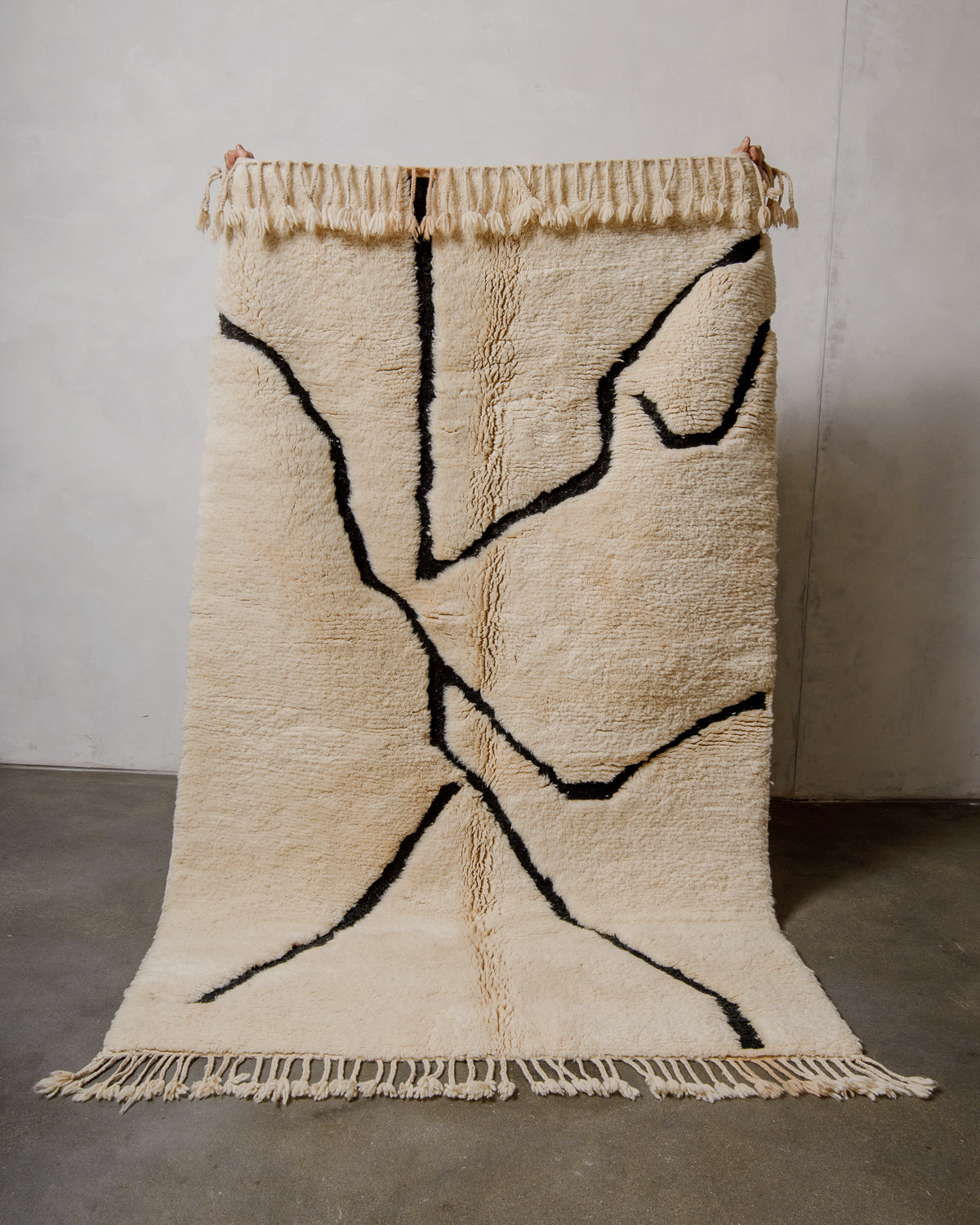 Beige and black abstract patterned rug on a plain background